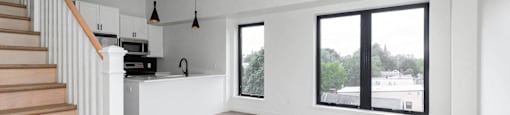 A spacious living room with a staircase on the left side.
