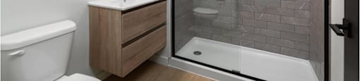 A bathroom with a white tub, a sink, and a glass shower door.