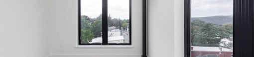 A room with a large window and wooden flooring.