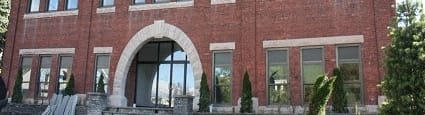 A red brick building with a white trim around the windows and a white arched entrance.