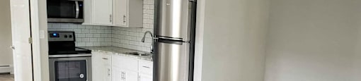 A kitchen with a stove top oven and a refrigerator.