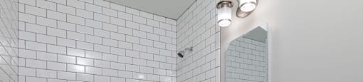 A white bathroom with a white tub, sink, and tiles.
