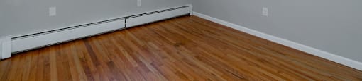 A room with a window and wooden floors.