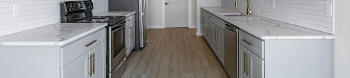 A kitchen with white cabinets and appliances.