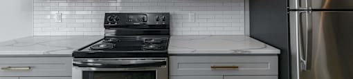 A kitchen with a stove, oven, microwave, and refrigerator.