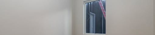 A room with a window and wooden flooring.