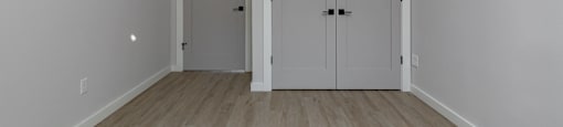 A room with two doors and a wooden floor.