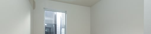 Empty room with a window and wooden floor.