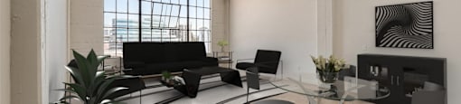 A living room with a black couch and a glass table.
