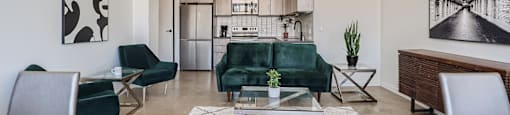 A modern living room with a green couch and a glass table.