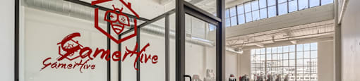 A glass room with a table and chairs and a logo on the glass.