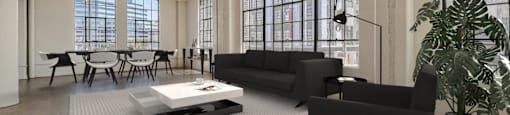 A black sofa sits in a spacious room with a white coffee table in front of it.