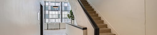 A staircase with a metal railing and a light hanging from the ceiling.