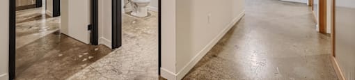A bathroom with a toilet and sink is reflected in a large mirror.