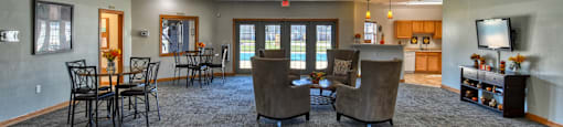 A spacious room with grey carpeting and a ceiling fan.