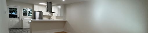 A room with wooden flooring and white walls.