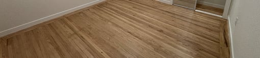 A room with wooden flooring and a white door.