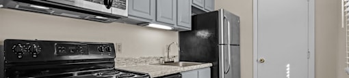 a kitchen with stainless steel appliances and white cabinets at Raleigh Rentals, Raleigh, NC, 27604