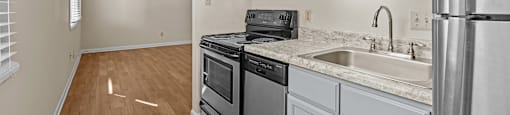 an empty kitchen with white cabinets and stainless steel appliances at Raleigh Rentals, North Carolina