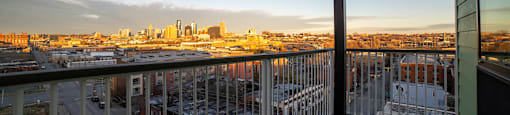 A balcony overlooks a cityscape at sunset.
