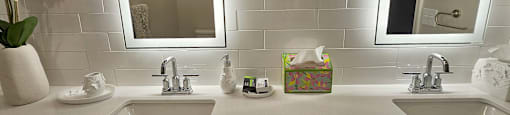 A bathroom with two sinks and a large mirror.
