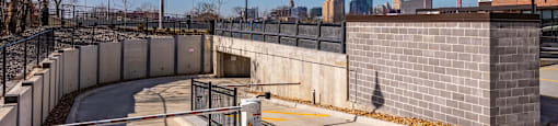 A concrete parking lot with a yellow line and a metal fence.