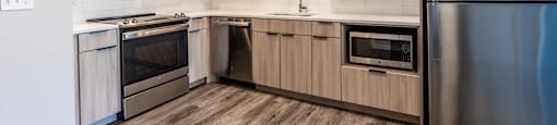 A modern kitchen with wooden cabinets and stainless steel appliances.