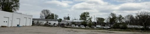 Parking lot with a white building and a yellow line in the middle.