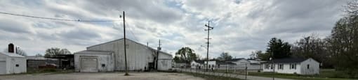 Large, empty parking lot with a few buildings in the background.