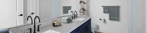 A modern bathroom with a double sink vanity and a striped rug on the floor.