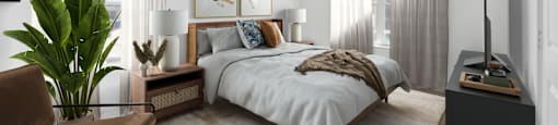 A bedroom with a large bed, a chair, and a plant.