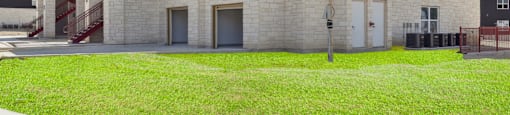 A large black and beige building with a grassy area in front.