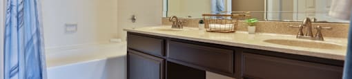A1 bathroom with a large mirror, a sink, and a bathtub at The Inverness Apartments in Houston, TX