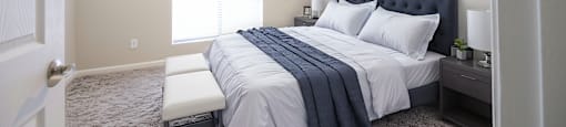a bedroom with a white bed and a blue and white comforter