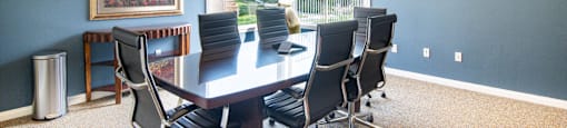 A conference room with a large table and chairs.