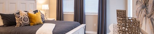 A bedroom with a large bed and a ceiling fan.