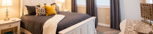 A bedroom with a large bed and a ceiling fan.