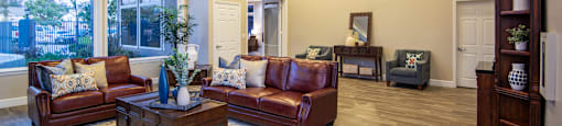 A living room with brown leather couches and a patterned rug.