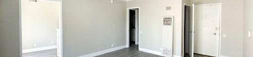 A spacious room with grey flooring and white walls.