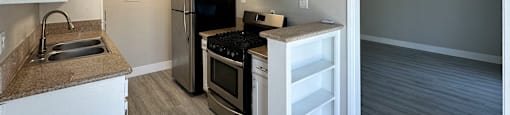 A kitchen with a black fridge and stove top oven.