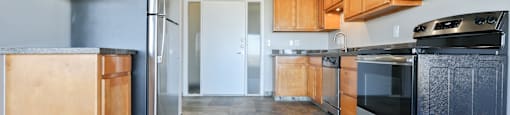 A kitchen with wooden cabinets and black appliances.