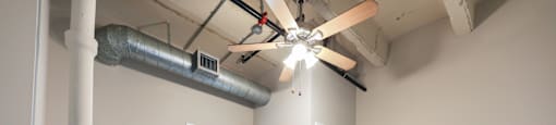 A room with a ceiling fan and a doorway leading to another room.