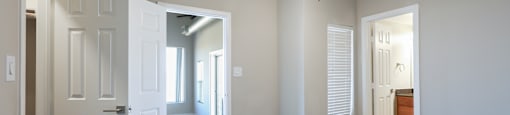 A room with a ceiling fan and a door.