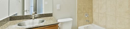 A bathroom with wood cabinets, shower and toilet