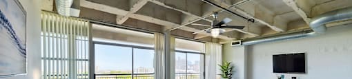 A bedroom with a large bed and a balcony overlooking the city.