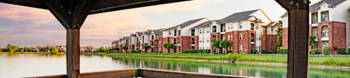 a view of a lake with an apartment complex in the background