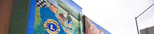 a mural on the side of a building with many photos and words on it