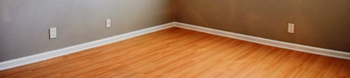 View of bedroom with wood look flooring, well lit window, and ceiling fan