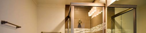 bathroom with in laid sink, white cabinets, large well lit mirror, toilet and tiled tub shower combo
