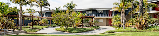 an apartment with palm trees in front of it